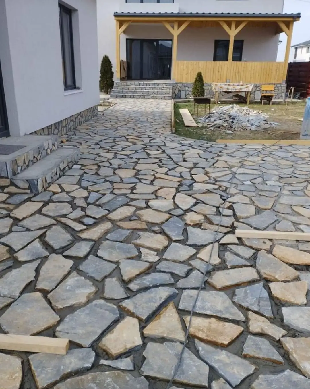 Curte pavată cu piatră decorativă în fața unei case cu terasă de lemn, Corbeanca, Ilfov