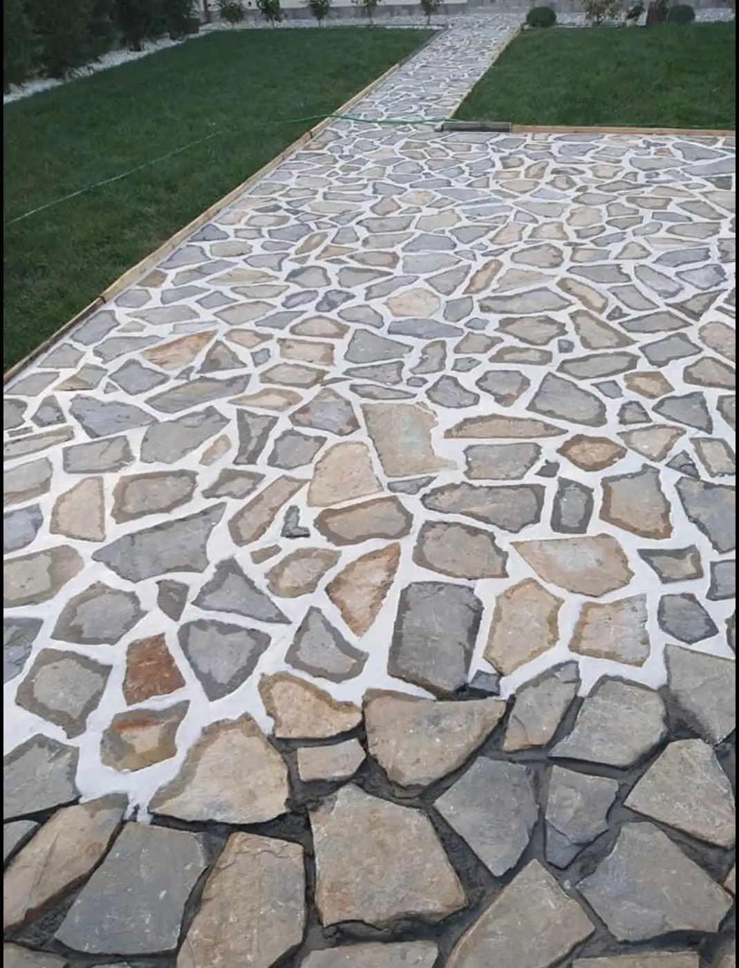 Alee lată din piatră decorativă cu rosturi albe, lângă gazon, Corbeanca
